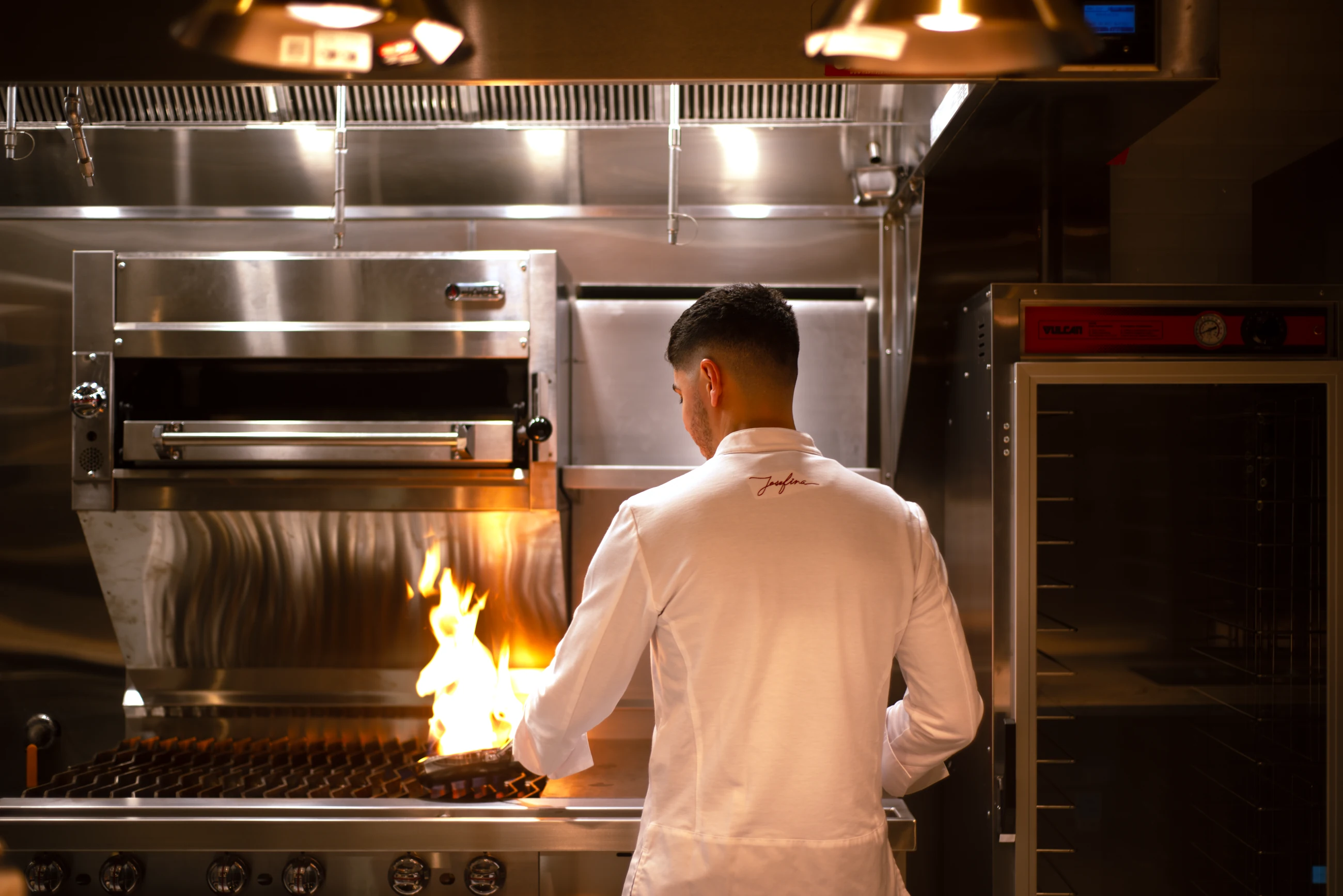 Executive Chef David Zamudio cooking over an open flame in the Josefina kitchen